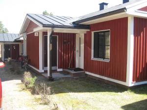une maison rouge avec une terrasse couverte et une fenêtre dans l'établissement Rt-huoneisto,Kulnevintie 2 as 3, 62300 HÄRMÄ, à Härmä