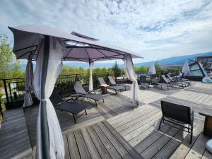 eine Terrasse mit Stühlen, einem Sonnenschirm und einem Tisch in der Unterkunft The Five Elements Hotel and SPA in Saparewa Banja