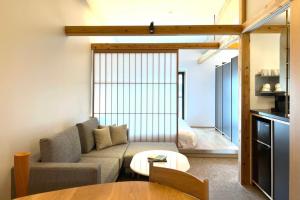 a living room with a couch and a table at Kyoto ITOYA Hotel Mon in Kyoto