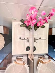une salle de bains avec des fleurs roses dans une armoire dans l'établissement Mirador Paraiso: Superb Sea View, à Playa Paraiso