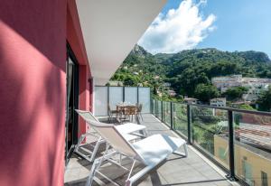 einen Balkon mit weißen Stühlen und einem Tisch darauf in der Unterkunft Olydea Beausoleil in Beausoleil