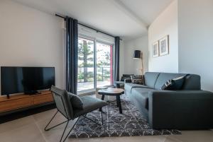 ein Wohnzimmer mit Couch und Fernseher in der Unterkunft Olydea Beausoleil in Beausoleil