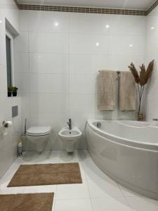 ein weißes Bad mit einer Badewanne und einem WC in der Unterkunft Pembroke St Julians Luxury, Comfort, Location in Pembroke