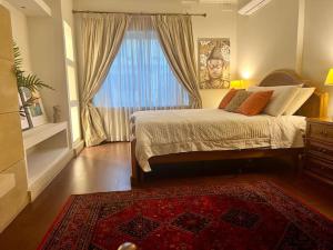 Schlafzimmer mit einem Bett, einem Fenster und einem Teppich in der Unterkunft Pembroke St Julians Luxury, Comfort, Location in Pembroke