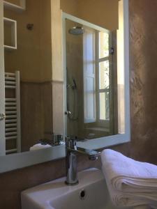 La salle de bains est pourvue d'un lavabo et d'un miroir. dans l'établissement Casa Rossa, à Portovenere