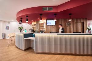 a person sitting at a counter in an office at ibis Styles Paris Poissy in Poissy