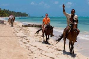 Dois homens andam a cavalo na praia. em Casa Paraíso - Little Corn Island em Corn Island