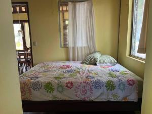 a bedroom with a bed with a colorful comforter at Casa Paraíso - Little Corn Island in Little Corn Island