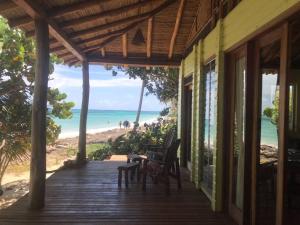 une terrasse couverte d'une maison avec vue sur la plage dans l'établissement Casa Paraíso - Little Corn Island, à Little Corn Island