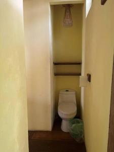 a small bathroom with a toilet in a hallway at Casa Paraíso - Little Corn Island in Little Corn Island