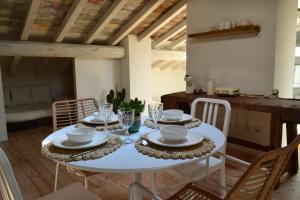 a dining room with a white table and chairs at La Locanda della Torre in Marne di Filago