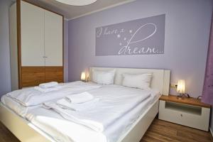 ein Schlafzimmer mit einem großen Bett mit weißer Bettwäsche in der Unterkunft strandnah, Balkon, AHOI Erlebnisbad gratis in Sellin - Strandresidenz Brandenburg FeWo 14 in Göhren