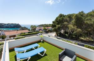 una vista dal balcone di una casa con due sedie blu di Villa Ermita by Sonne Villas a Cala Galdana