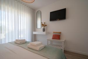a bedroom with a bed with towels on it at Casa Cabanas - Cabanas Gardens in Cabanas de Tavira