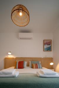 a bedroom with two beds and a chandelier at Casa Cabanas - Cabanas Gardens in Cabanas de Tavira