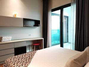 a bedroom with a bed and a desk and a window at Geo 38 Residence Genting Highland in Genting Highlands