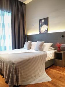 una camera da letto con un grande letto con lenzuola bianche e una finestra di Geo 38 Residence Genting Highland a Resorts World Genting