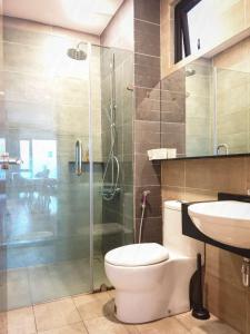 a bathroom with a toilet and a glass shower at Geo 38 Residence Genting Highland in Genting Highlands