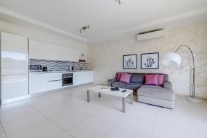 ein Wohnzimmer mit Couch und Tisch in der Unterkunft Modern Apartment steps from Balluta Bay in Sliema + 22 Fotos