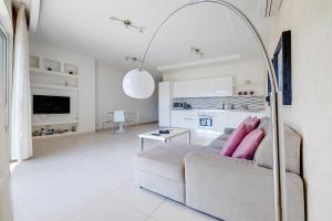 - un salon blanc avec un canapé et une table dans l'établissement Modern Apartment steps from Balluta Bay, à Sliema