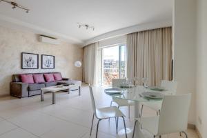 - un salon avec une table et un canapé dans l'établissement Modern Apartment steps from Balluta Bay, à Sliema