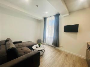 a living room with a couch and a table at Apartamentai Sandra in Klaipėda +1 photo