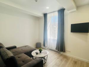 a living room with a couch and a table at Apartamentai Sandra in Klaipėda