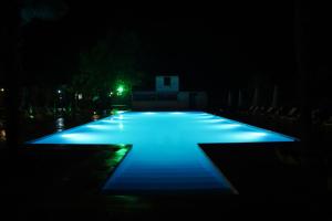 una piscina illuminata di notte con luci blu di Wald Hotel Lagodekhi a Lagodekhi