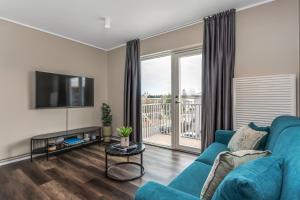 a living room with a blue couch and a tv at Snorrabraut Apartments By Alva in Reykjavík