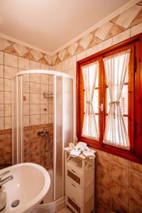 La salle de bains est pourvue d'une baignoire, d'un lavabo et d'une douche. dans l'établissement Kymanemi Zakynthos Cottage House, à Áno Yerakaríon