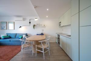 a kitchen and living room with a table and chairs at Casa Cabanas - Cabanas Gardens in Cabanas de Tavira