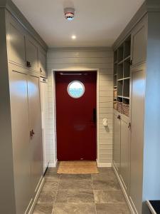 a red door with a window in a hallway at Sadelbyn Fjällhem in Åre +26 photos