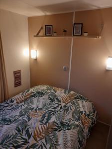 a bedroom with a bed and two shelves on the wall at la dune blanche in Camiers