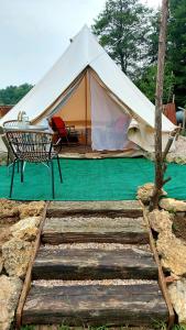 a tent with a table and a bench in front at Dream Glamping-Wakacyjna Wioska-Namioty z ogrzewaniem in Bałtów