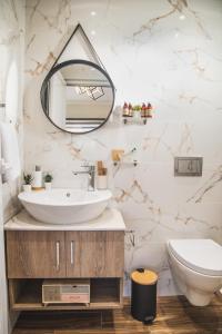 uma casa de banho com um lavatório e um espelho em JnS Faliraki Penthouse em Kallithea Rhodes