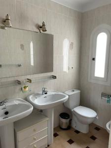 een badkamer met een wastafel, een toilet en een spiegel bij Verano Azul 12 Menyber in Nerja