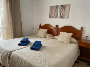 twee blauwe handdoeken zitten op een bed bij Verano Azul 12 Menyber in Nerja