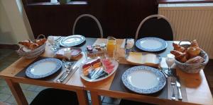 a table with blue and white plates and baskets of food at Auberge au pont de Villettes in Lierneux