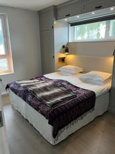 Un dormitorio con una cama grande con una manta. en Sadelbyn Fjällhem, en Åre