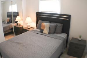 a bedroom with a bed and two lamps and a mirror at 3 BR Southside Pad - Sleeps 8 - Amazing Location in Pittsburgh