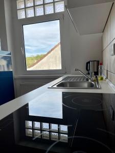a small kitchen with a sink and a window at Elsasser Haus - 2 Zimmer, 3 Betten, 5 Personen, kontaktloses Einchecken, Netflix in Wuppertal