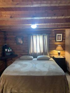Un dormitorio con una cama grande con ventana. en Log Cabin in the Field, en Huntington