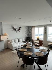 uma sala de estar com um sofá, uma mesa e cadeiras em Sadelbyn Fjällhem em Åre