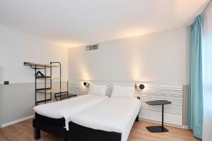 Un dormitorio con una gran cama blanca y un estante en ibis Styles Paris Poissy, en Poissy