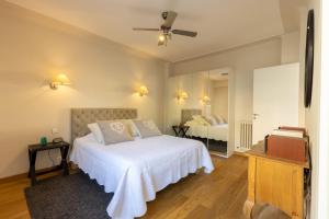 a bedroom with a white bed and a mirror at Elégant appartement proche bord de mer in Beaulieu-sur-Mer