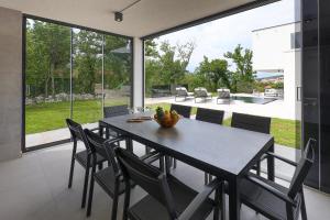 een eetkamer met een tafel en stoelen bij Luxury Villa Cloer, Jadranovo - NEW 5 star Villa 100m from the sea in Jadranovo