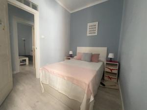 1 dormitorio con 1 cama blanca grande con almohadas rosas en Retiro, Atocha, Paseo del Prado. Pacifico Madrid 28007., en Madrid