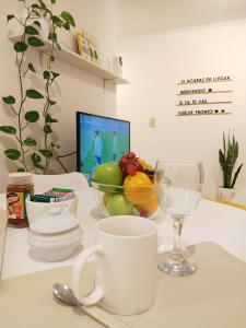 a table with a cup and a bowl of fruit at NUEVA CORDOBA Apartamento ILLIA, Excelente ubicación!!! in Córdoba