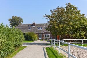 a house with a white fence in front of it at Ferienhof Gerdes in Holtgast