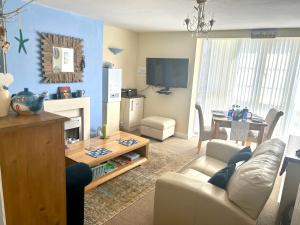 een woonkamer met een bank en een tafel bij BAKERY CENTRAL in Cromer